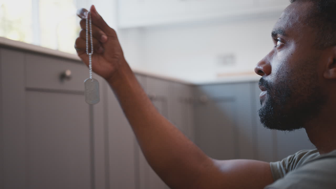 soldado deprimido en uniforme sufriendo de tept se sienta en el suelo en licencia de casa mirando la etiqueta del perro