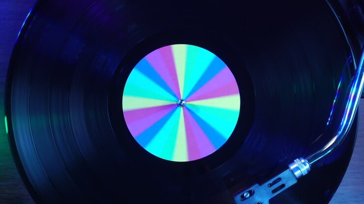 Starting Audio Playback of Vinyl Record With Rainbow Sticker and Colorful Disco Lights, Top Down View