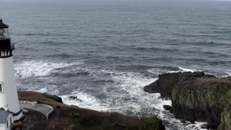 Beautiful-aerial-drone-view,-Yaquina-Head-Lighthouse,-pass-over-ocean