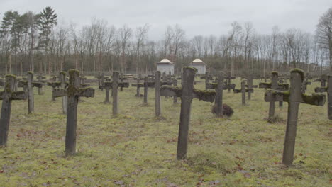 tilt down from cloudy sky to crucifixes at abandoned graveyard