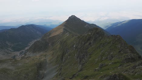 drone vuela sobre una cresta montañosa y revela una gran montaña y un hermoso paisaje en el fondo, cárpatos, rumania, europa, drone, verano