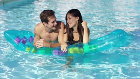 Linda-Pareja-Relajándose-En-Un-Colchón-Flotante-En-La-Piscina