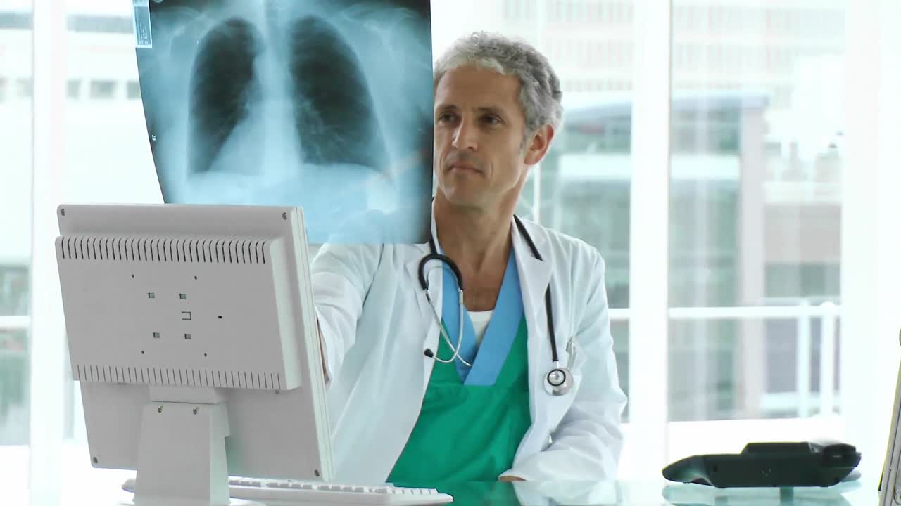 un médico serio mirando las radiografías