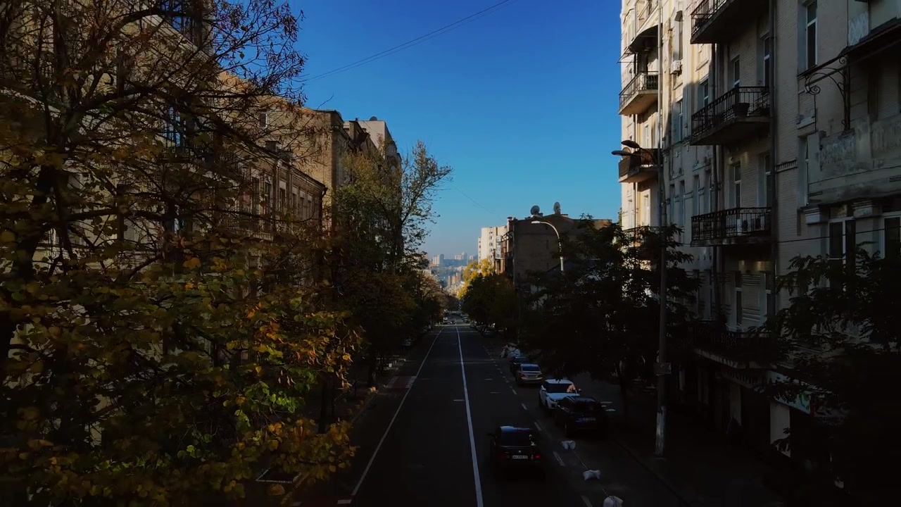 Low altitude aerial tracking down urban avenue with vintage facades in Kyiv