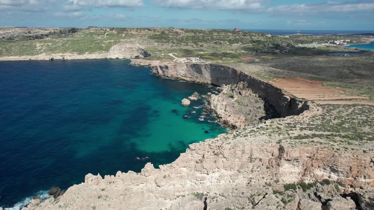 vista aérea de una costa rocosa en malta, con playas rocosas y agua de mar turquesa