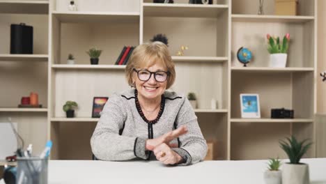 old-charismatic-woman-conducts-an-online-conversation-while-gesturing-with-her-hands