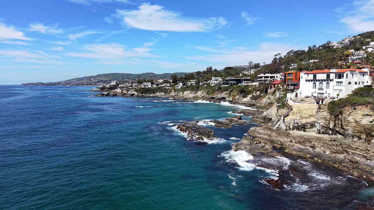 Riprese con drone di lussuose case fronte mare e scogliere orlate di palme che si affacciano sull'oceano