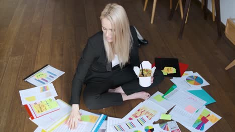 Young-business-woman-working-and-eating-asian-food