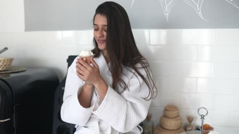 mujer disfrutando de un pastel en su cocina