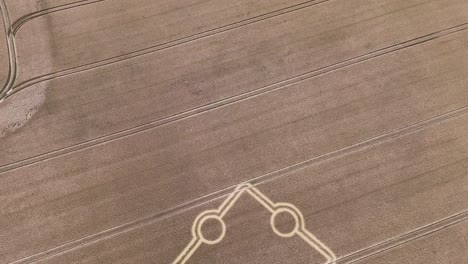 Aerial-view-overlooking-Stone-Henge-crop-circle-formation-on-rural-golden-farmland