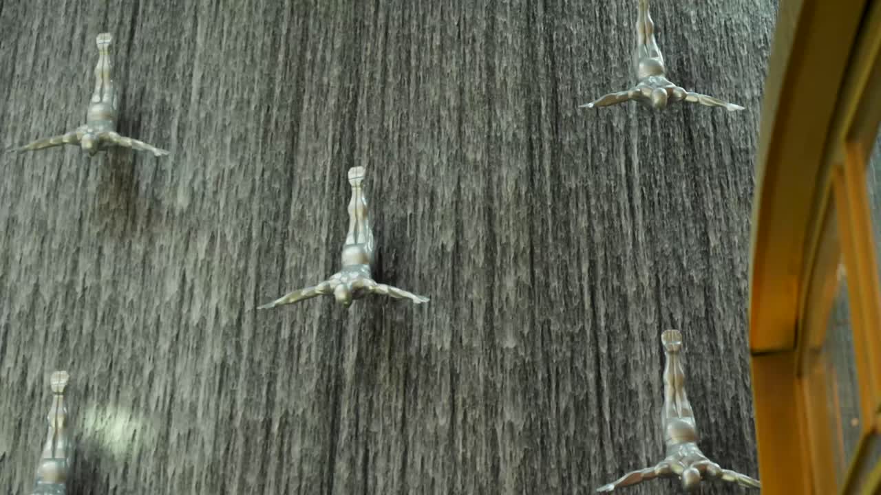 쇼핑몰 에 있는 다이버 들 의 조각품 이 있는 폭포