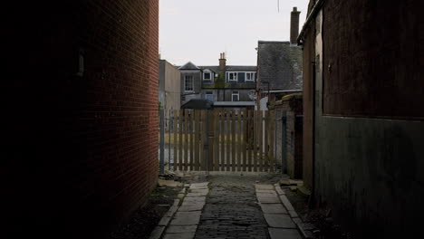 gloomy view on a typical back alley view between houses in united kingdom