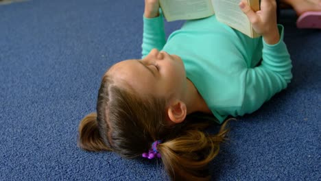 Vorderansicht-Einer-Aufmerksamen-Kaukasischen-Schülerin,-Die-In-Der-Bibliothek-Der-Schule-Ein-Buch-Liest,-4k