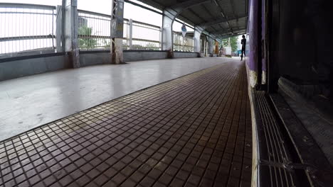 low angle of man stepping off a train onto a quite platform