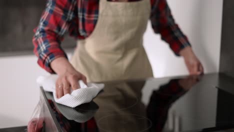 Mujer-Limpiando-El-Panel-De-Cocina-De-La-Estufa-Moderna-En-La-Cocina