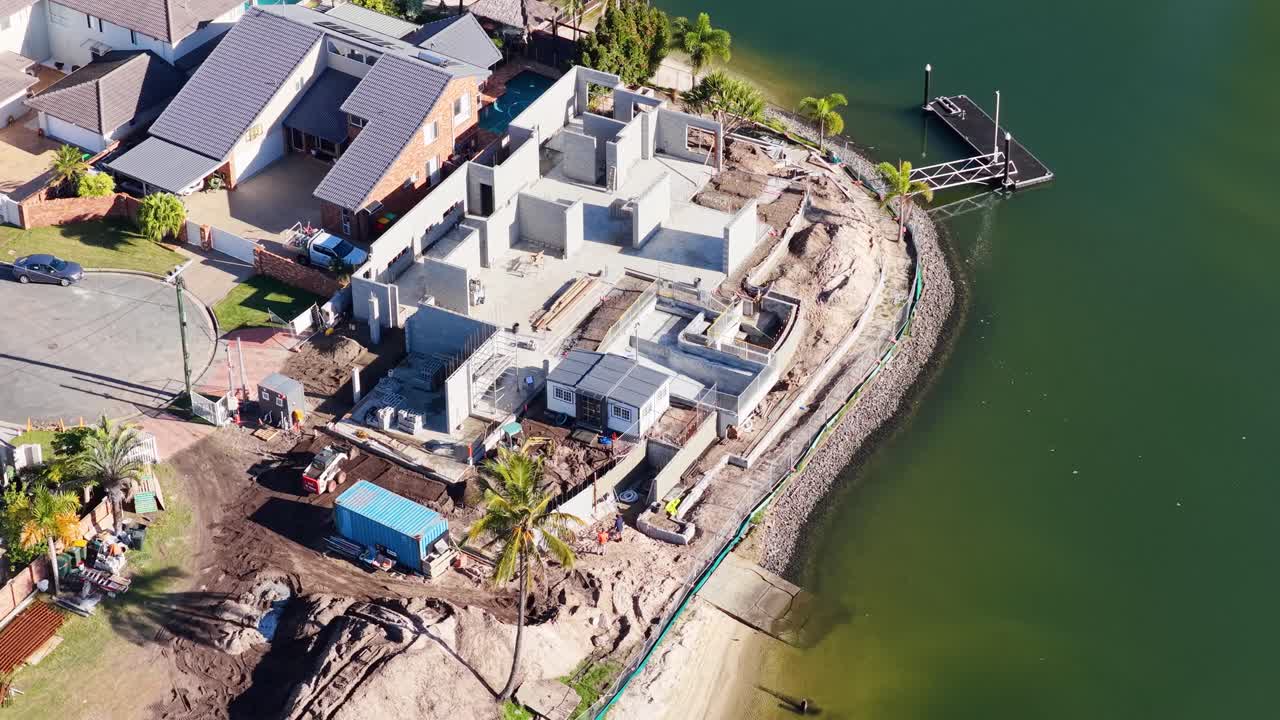 Drone captures construction progress along a canal in Gold Coast, Australia, highlighting new luxury homes and surrounding environment