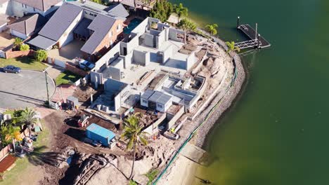 drone captures construction progress along a canal in gold coast, australia, highlighting new luxury homes and surrounding environment