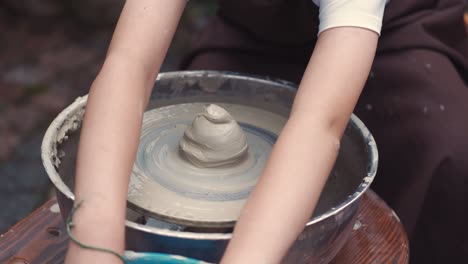 close up hands make pitchers in pottery