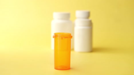 orange and white pill bottles on yellow background