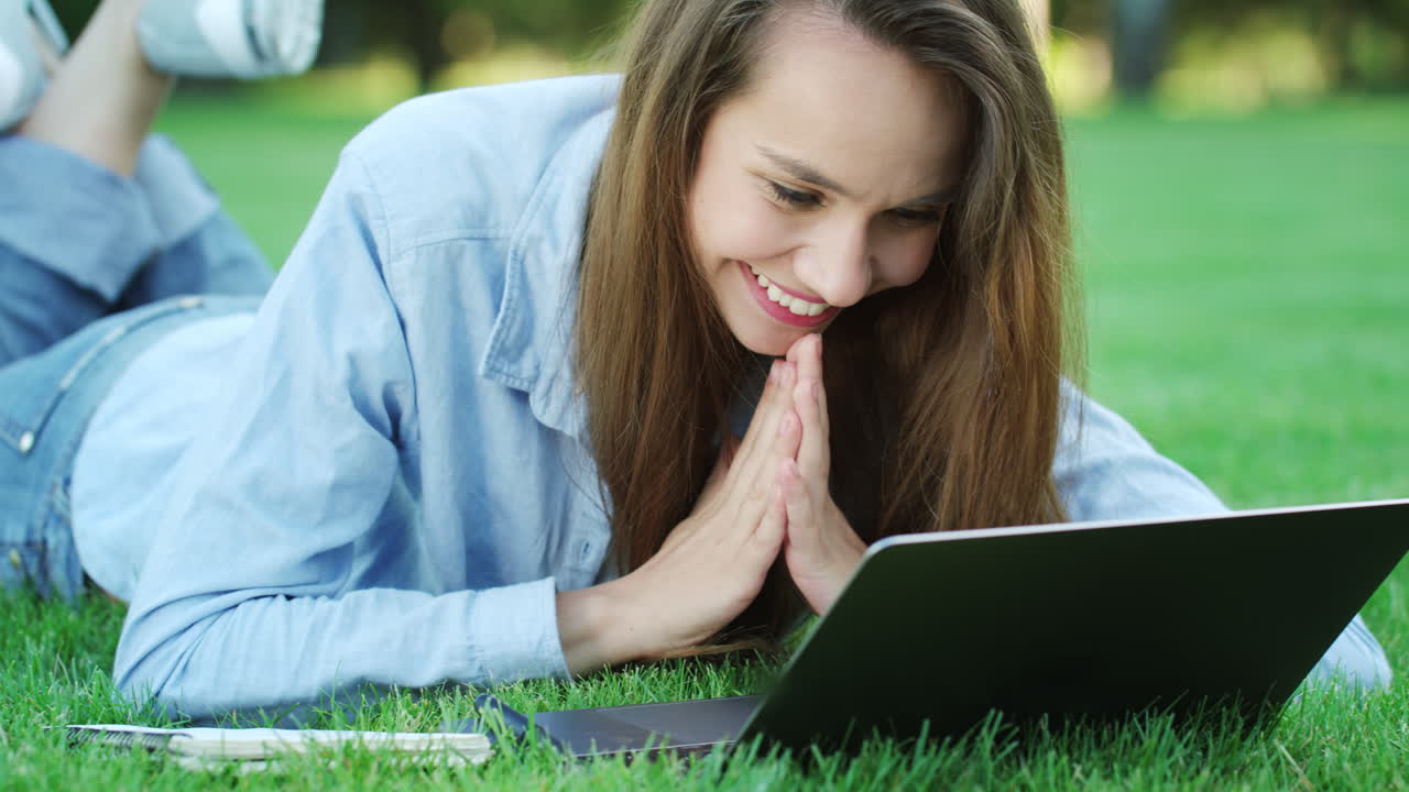 초록 잔디에 누워 있는 웃는 여자