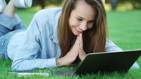 smiling woman lying on green lawn