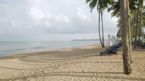 Luxury-beach-lounge-beds-with-umbrella-on-white-sand-beach