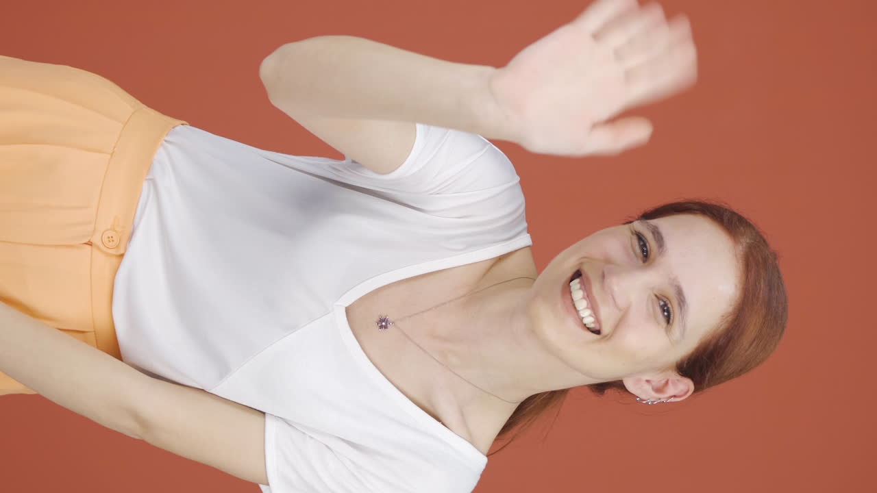 video vertical de una mujer feliz saludando a la cámara.