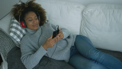 Mujer-Joven-Relajarse-En-El-Sofá-Con-Gadgets