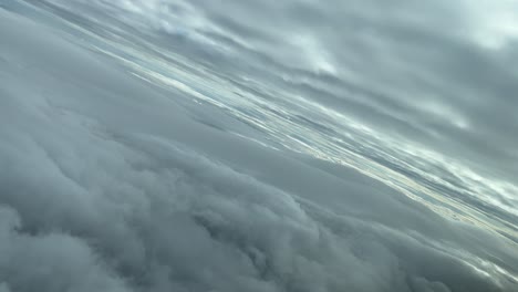 pov aerial cloudscape shot from an airplane cabin flying across layers of clouds turning left