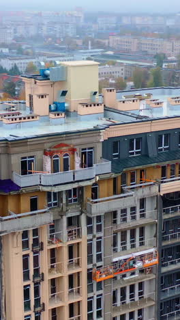 construction site in the city. modern architecture is building by workers. high-rise building under construction. camera moves in a round way. aerial view. vertical video