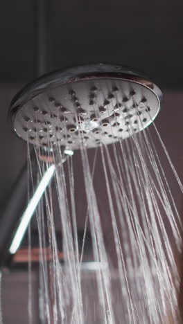 woman taking hot shower to clean body and head. lady doing evening cleansing routine in shower. female brunette enjoys strong pressure of water