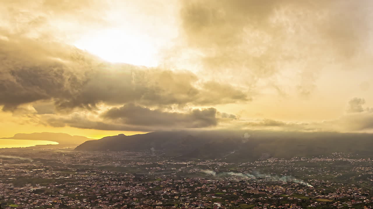 vista panorámica de la ciudad de palermo en primer plano y la cordillera junto con la costa del mar mediterráneo en el fondo de la ciudad de monreale, sicilia, italia en una noche nublada
