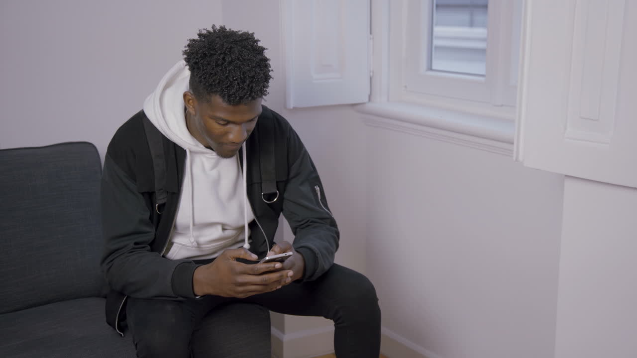 Portrait of concentrated African American man texting message