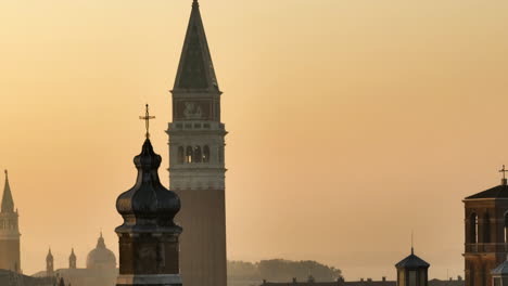 view at sunrise of bell towers of churches in venice, italy