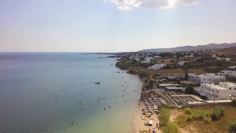 Aufsteigende-Drohnenaufnahme-Von-Touristen,-Die-Den-Goldenen-Strand-Auf-Der-Griechischen-Insel-Paros-Genießen