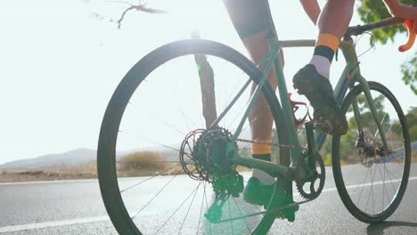 Con-La-Carretera-Sola,-Un-Hombre-Anda-En-Bicicleta-De-Carretera-Durante-La-Mañana-Y-Practica-Ejercicio-Al-Aire-Libre.-La-Representación-En-Cámara-Lenta-Intensifica-El-Espíritu-De-Los-Deportes-Extremos.