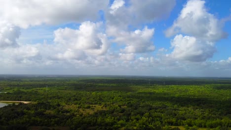 A-descending-aerial-shot-of-a-southern-grassland-on-a-partly-cloudy-day,-at-60-frames