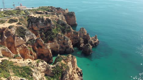 West-side-of-scarp-cliff-in-Ponta-da-Piedade-at-midday,-Lagos,-Algarve,-Portugal---Aerial-Fly-over-shot