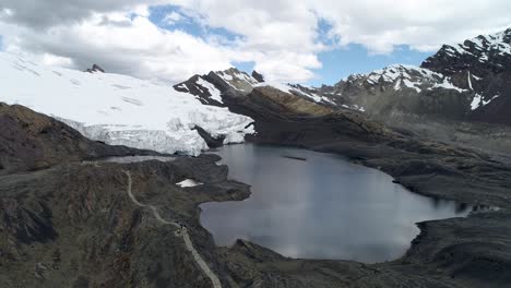 a stunning glacial lake mirrors the snow-covered peaks of the peruvian andes. perfect for travel blogs, prints, and adventure
