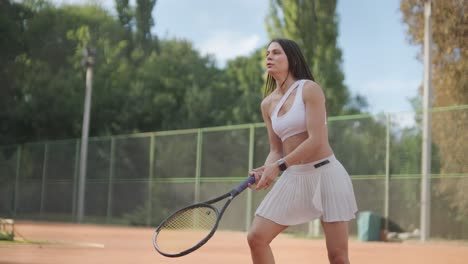 female tennis player practicing serve on outdoor court