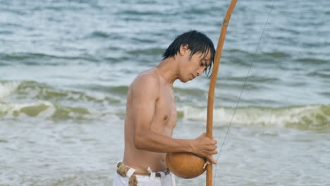 shirtless musician playing instrument