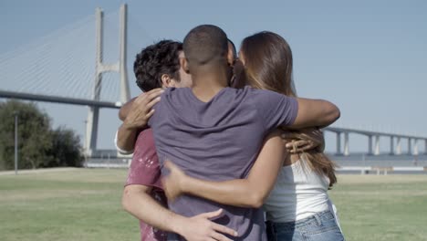 happy smiling friends hugging in circle and talking.