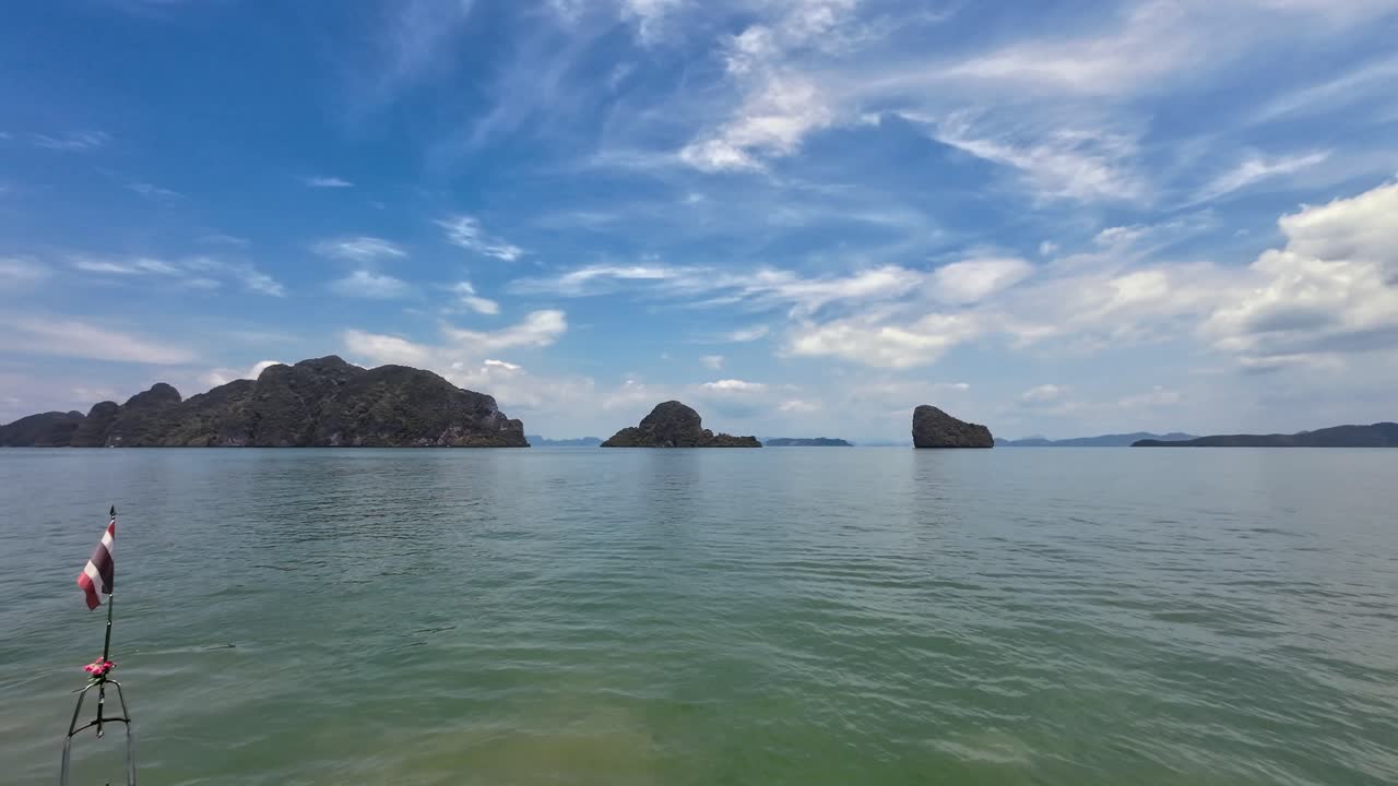 A scenic boat ride through towering limestone cliffs in Phang Nga Bay, Phuket, Thailand, featuring tropical waters, dramatic karst formations, and a popular travel destination