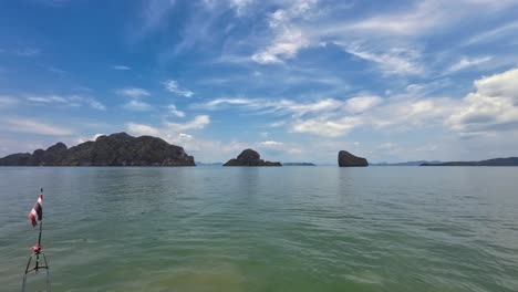 a scenic boat ride through towering limestone cliffs in phang nga bay, phuket, thailand, featuring tropical waters, dramatic karst formations, and a popular travel destination