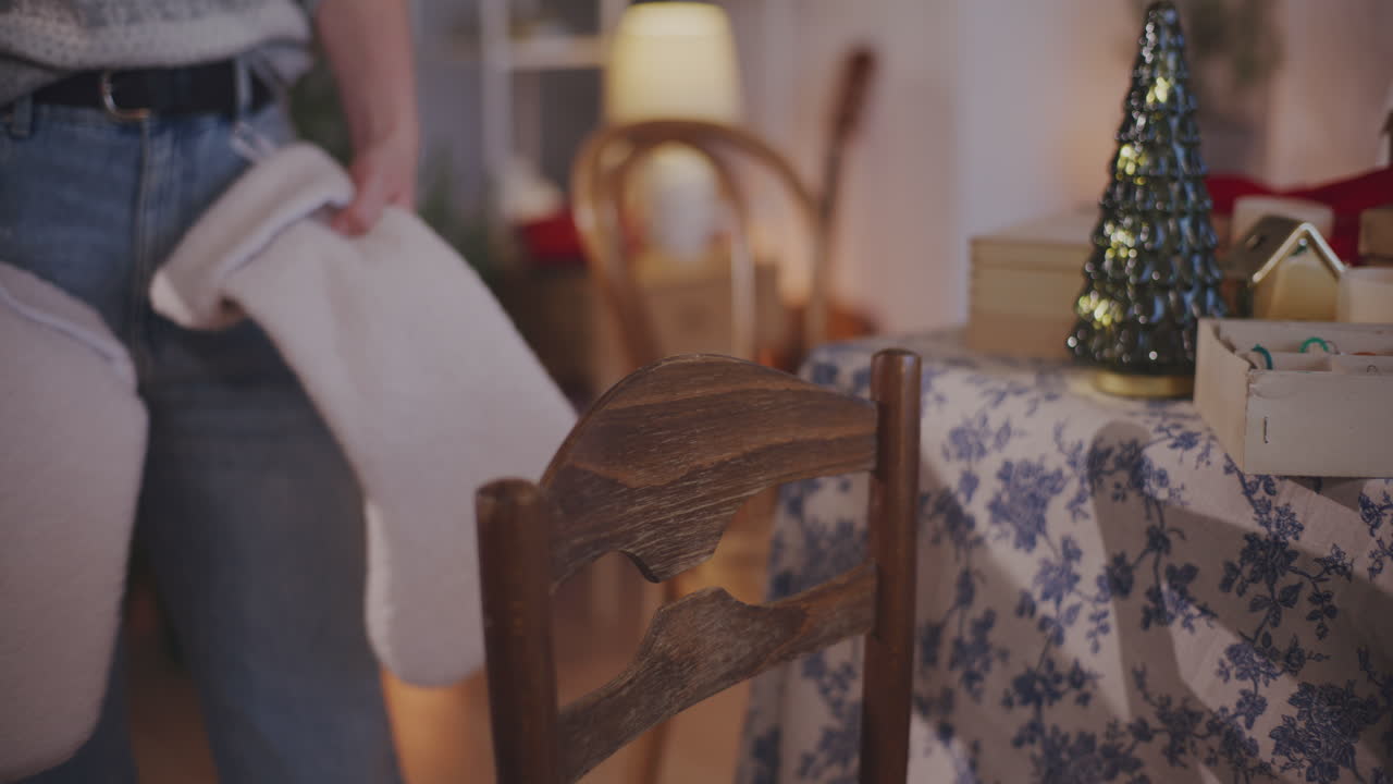 mujer poniendo medias de navidad en la silla en casa