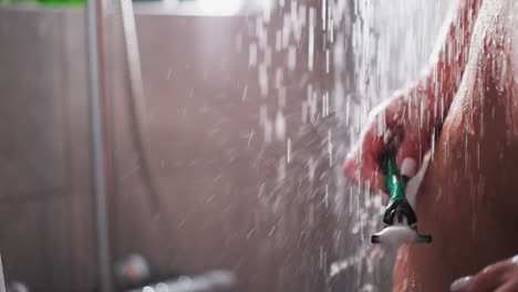 mujer con afeitadora está en la ducha el flujo de agua de primer plano. dama desnuda con cuerpo delgado se prepara para quitar el cabello en el baño. privacidad en el baño de casa