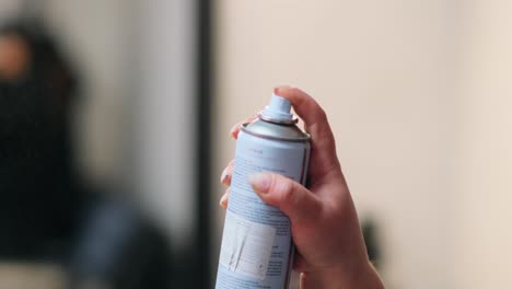 Girl holding in her hand deodorant for hair
