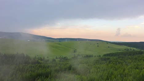 Beautiful-Drone-shot-over-green-mountains-and-forest-at-sunset