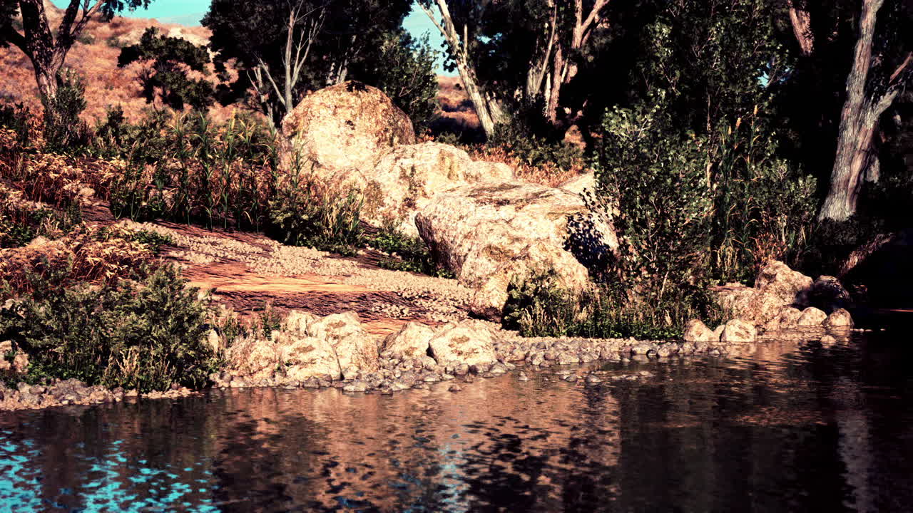 밝은 낮 동안 바위와 울창한 초록색으로 평온한 강변 설정