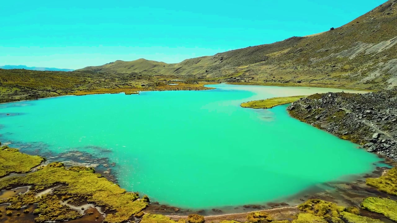 Uma perspectiva aérea nítida e de grande angular capturando as águas azuis vívidas e ricas em minerais dos lagos glaciais sob os picos irregulares da Cordilheira de Vilcanota.